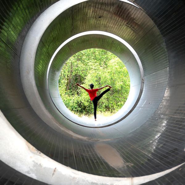 Person doing a challenging yoga balance pose in nature.